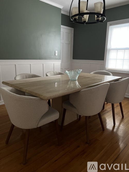 A dining room with a table and chairs.