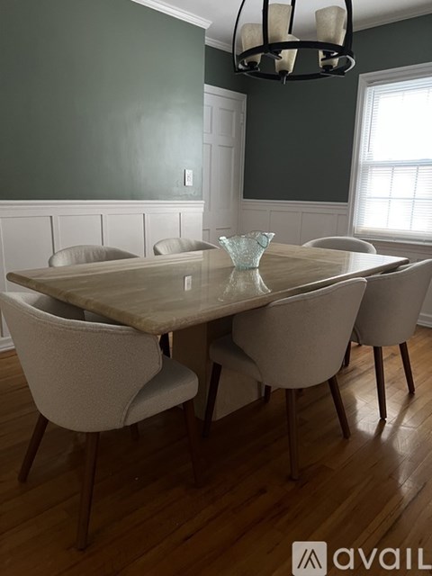 A dining room with a table and chairs.