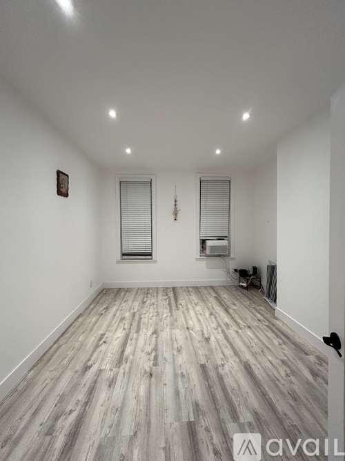 A room with wooden flooring and white walls.