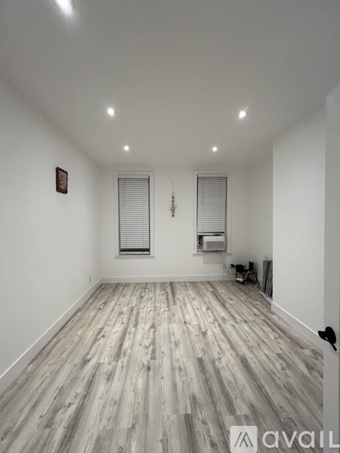 A room with wooden flooring and white walls.