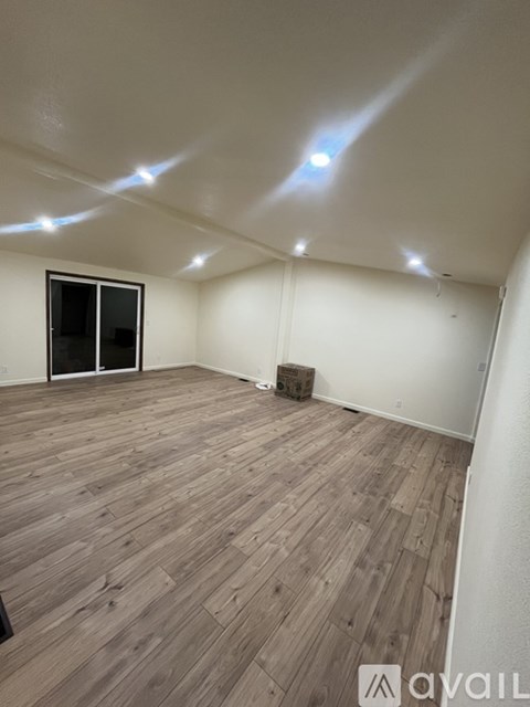A room with wooden flooring and a window.
