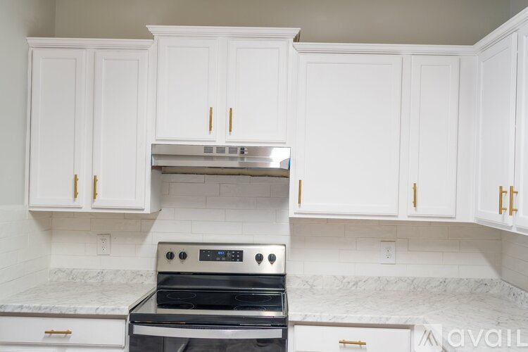 A kitchen with white cabinets and a black stove top oven.