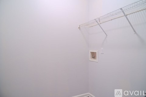 A white wall with a shelf and a light switch.
