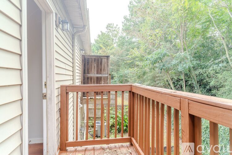 A wooden deck with a view of trees and a shed.