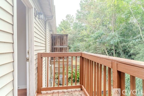 A wooden deck with a view of trees and a shed.