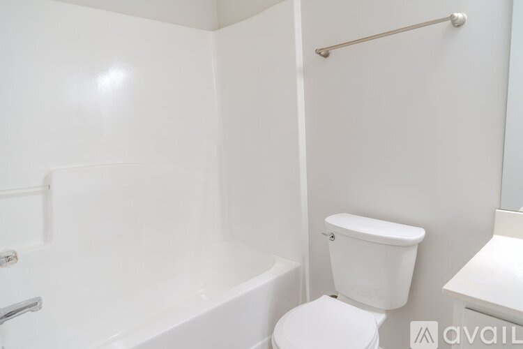 A white toilet sits next to a bathtub in a bathroom.