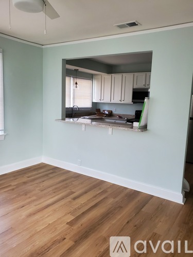 A room with wooden floors and a mirror on the wall.