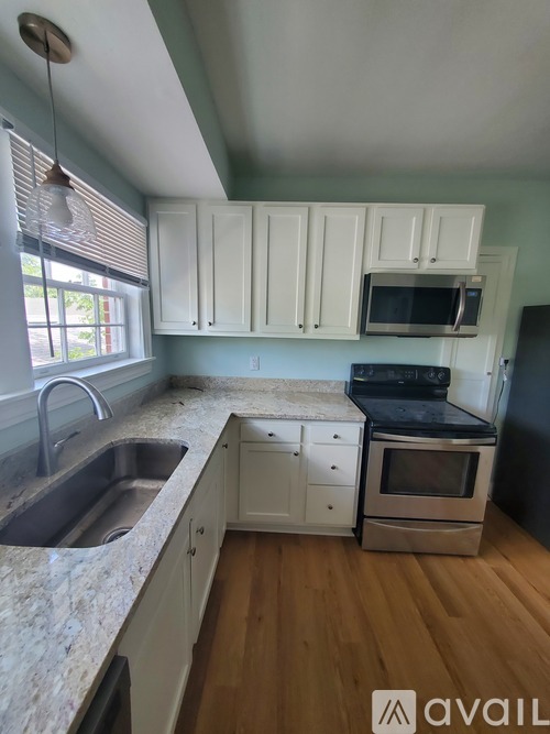 A kitchen with white cabinets and a granite countertop.