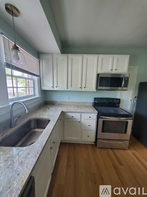 A kitchen with white cabinets and a granite countertop.
