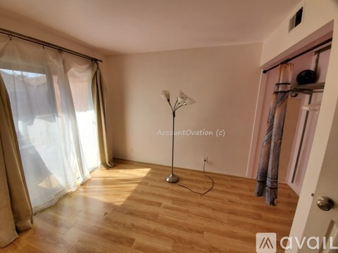 A room with a wooden floor and a floor lamp.