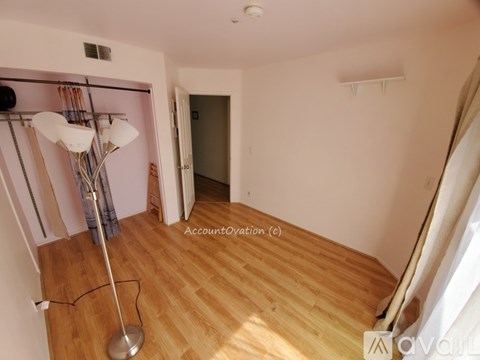 A room with wooden floors and a lamp on the floor.
