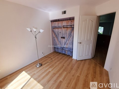 A room with a wooden floor and a white door.