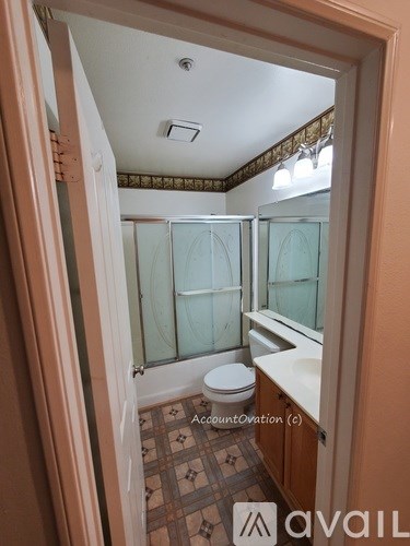 A bathroom with a toilet, sink, and shower.