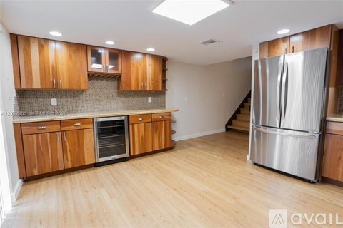 A kitchen with wooden cabinets and a stainless steel refrigerator.