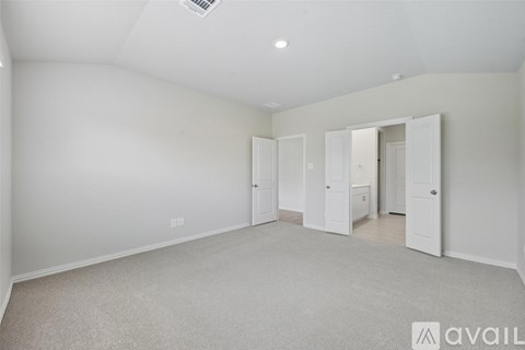 A spacious room with white walls and carpeted floor.