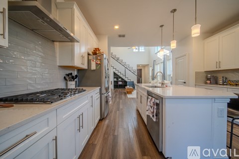 A kitchen with white cabinets and a wooden floor.