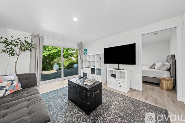 A living room with a grey couch and a black coffee table.