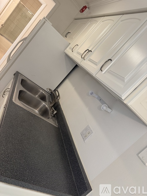 A kitchen with a dishwasher and white cabinets.