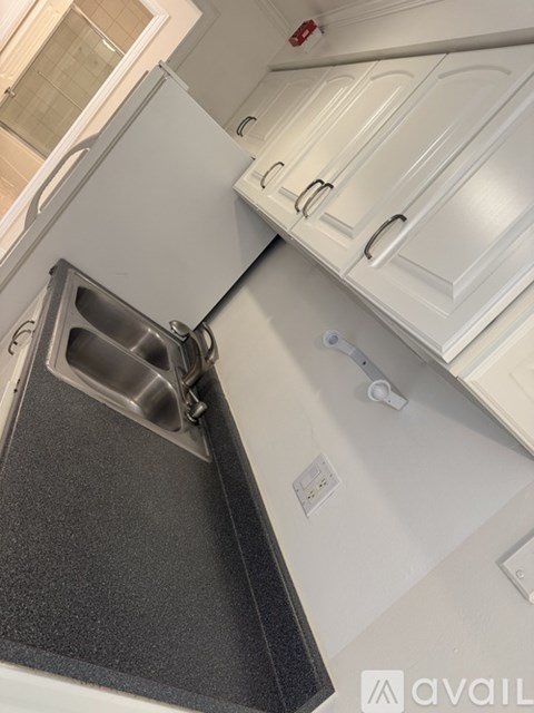 A kitchen with a dishwasher and white cabinets.