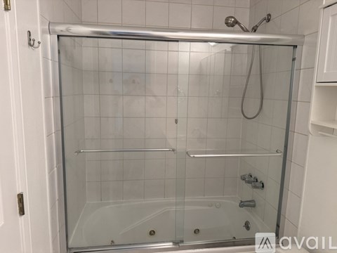 A glass shower stall with a silver frame and a silver shower head.