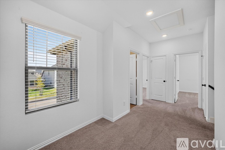 A room with white walls and carpeted floor with a window on the left side.