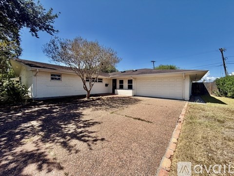 A house with a white garage door and a tree in front.