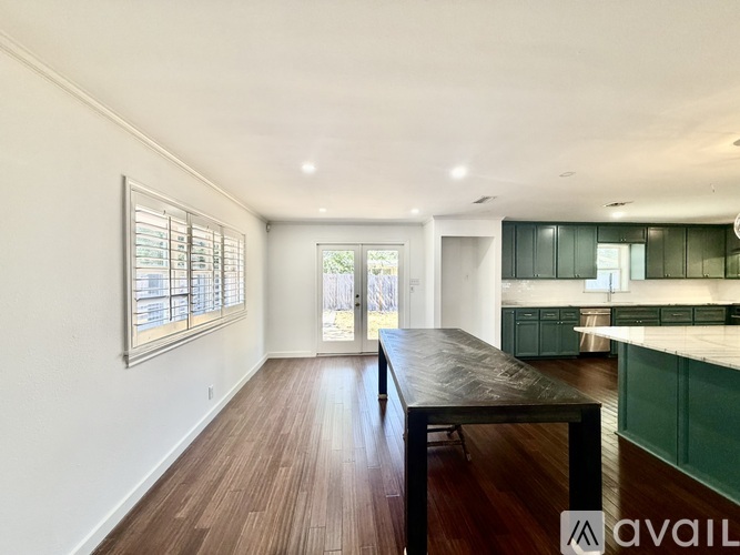 A spacious room with a long table and wooden floor.