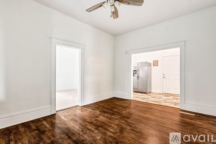 A room with a wooden floor and a ceiling fan.