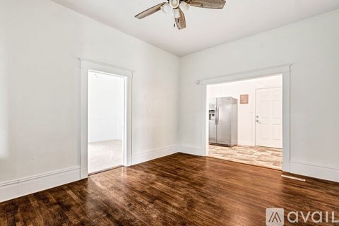 A room with a wooden floor and a ceiling fan.