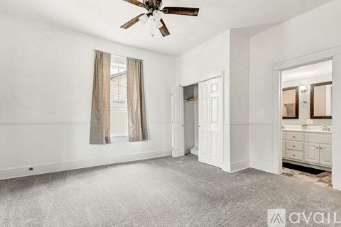 A spacious room with a ceiling fan and a carpeted floor.