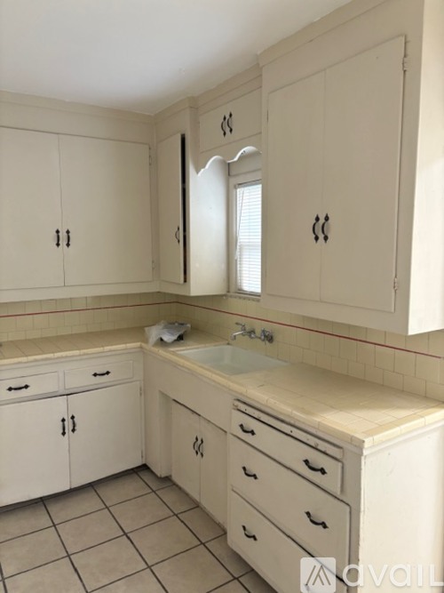 A bathroom with white cabinets and a sink.
