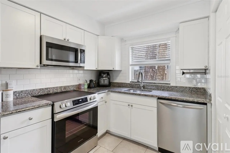 A kitchen with white cabinets and a granite countertop.