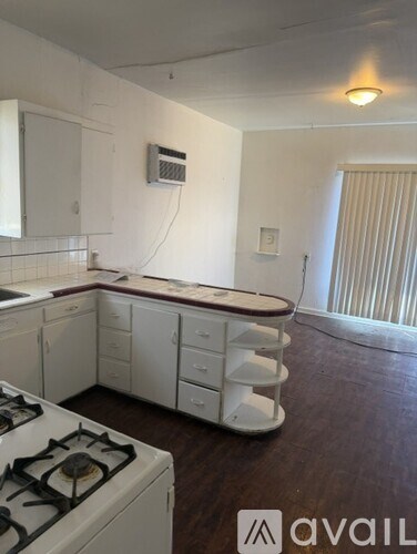 A kitchen with white cabinets and a white stove top oven.