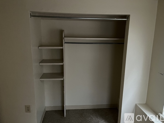 A white closet with shelves and a door open.