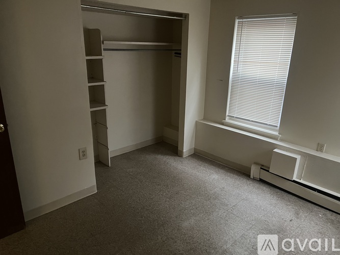 A room with a window and a built in shelf unit.