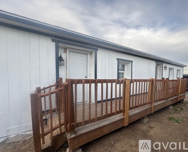 A white building with a wooden fence in front.