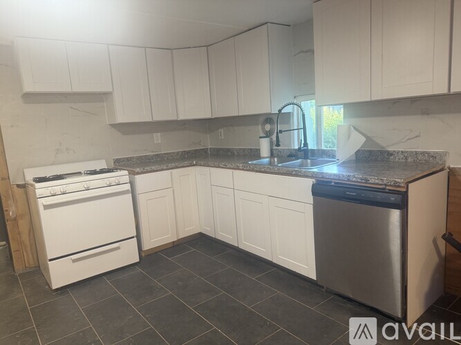 A kitchen with white cabinets and a stainless steel dishwasher.