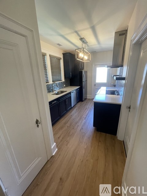A kitchen with wooden floors and white walls.