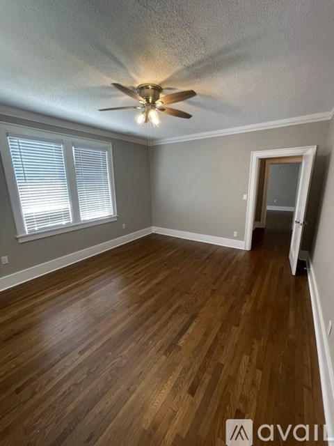 A room with wooden floors and a ceiling fan.
