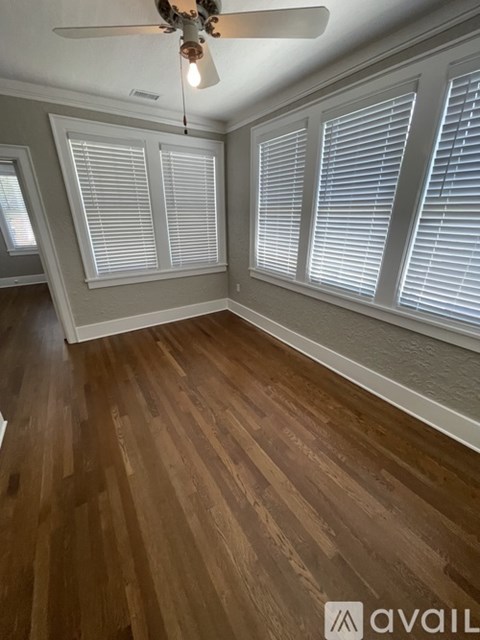 A room with wooden floors and a ceiling fan.