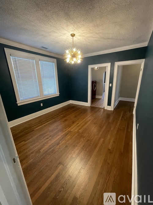 A room with wooden floors and a chandelier.