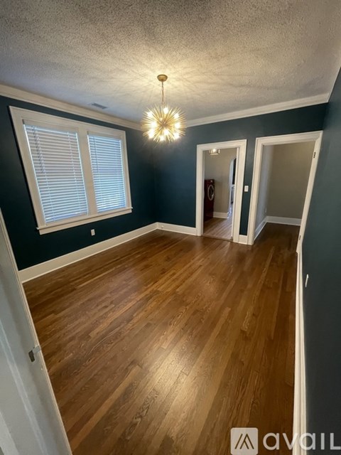 A room with wooden floors and a chandelier.