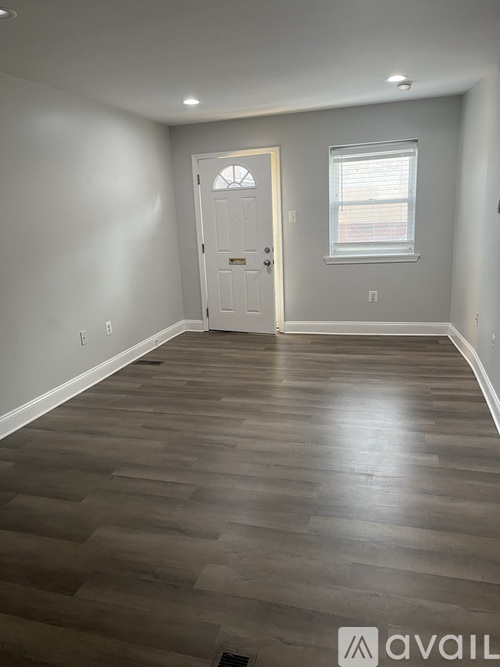 A room with a wooden floor and a white door.