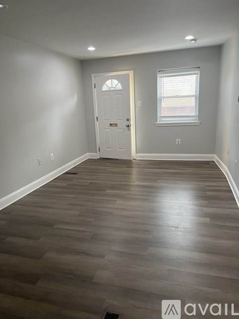 A room with a wooden floor and a white door.