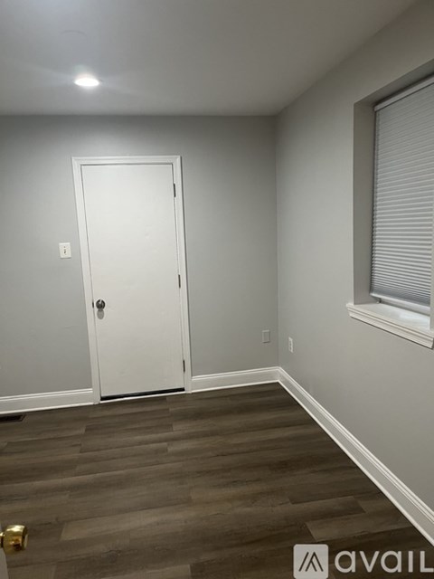 A room with a white door and a window with blinds.
