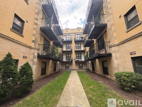 A building with a balcony and a walkway in front.