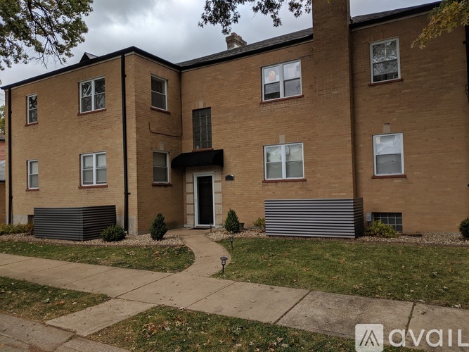 A brick apartment building with a cloudy sky in the background.