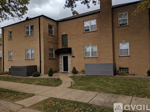 A brick apartment building with a cloudy sky in the background.