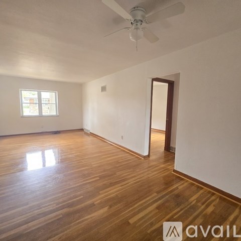 A room with wooden floors and a ceiling fan.