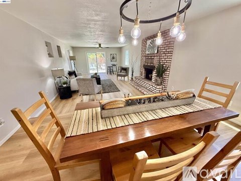 A dining room with a wooden table and chairs.